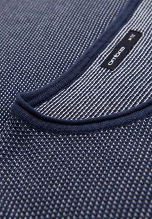 Laivastonsininen tekstiili, jossa on verkkokuvio ja pyöristetty pääntie. Varustettu mustalla tarralla, jossa on "ombre"-brändäys.