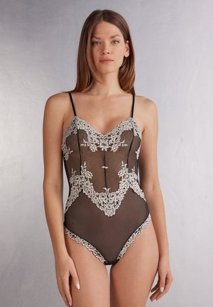 Zwarte kanten bodysuit met een bloemmotief in kant, verstelbare banden en sheer mesh details, die een getailleerde en delicate uitstraling biedt.