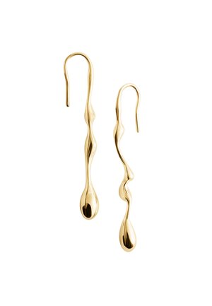 Orecchini pendenti d'oro asimmetrici con forme lisce, organiche e ondulate e estremità allungate a goccia, esposti su uno sfondo bianco.