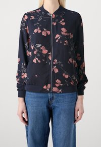 Lätt bomberjacka med dragkedja framtill i marinblått med rosa blommönster. Har ribbad mudd och nederkant samt en avslappnad passform. Lämplig för vardagsbruk.