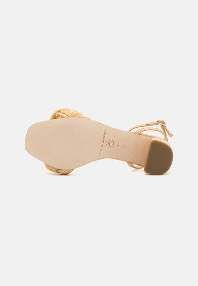 Rem-strap hæl sandal, vævet gyldent materiale, åben tå design, flad sål, lys tan fodseng, lynlås i siden, lav gummihæl.