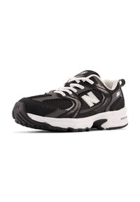 Chaussure de sport noire avec une tige en maille et synthétique, lacets blancs, semelle en caoutchouc et accents texturés. Présente un logo proéminent sur le côté.