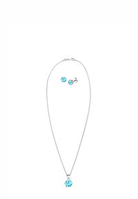 Sølvhalskæde med vedhæng af en lys blå ædelsten i midten, ledsaget af matchende lys blå øreringe med knapform. Simpelt og elegant design.