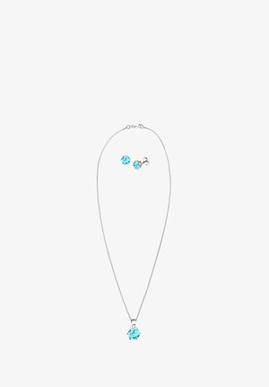 Strieborný náhrdelník so svetlomodrým drahokamovým príveskom v strede, sprevádzaný náušnicami s rovnakým svetlomodrým drahokamom. Jednoduchý a elegantný dizajn.