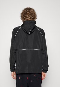 veste nike noire et blanche