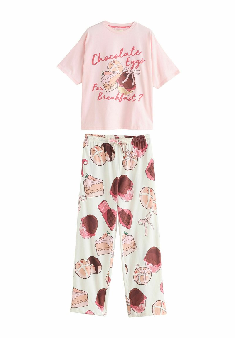 Lyserød bomulds t-shirt med en grafik der har tekst, parret med hvide pyjamasbukser prydet med dessertmønstre i pink og brun.