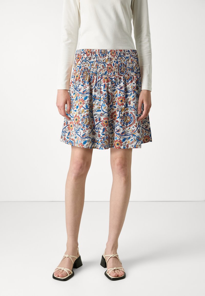 Falda de longitud hasta la rodilla con estampado floral y cinturilla fruncida. Colores vibrantes que incluyen rojo, azul y amarillo sobre un fondo blanco.