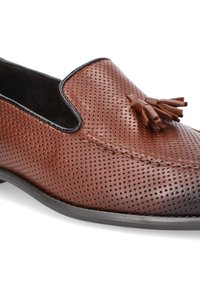 Brązowy perforowany skórzany but wsuwany z czarnym wykończeniem, z małym detalem w postaci frędzelka z przodu oraz niską, płaską podeszwą.