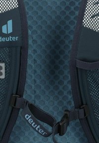 Panel de mochila de malla azul oscuro con patrones hexagonales intrincados, correas ajustables y un destacado logotipo de "deuter" en un azul claro contrastante.