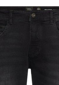 Black denim jeans with a relaxed fit, featuring a button closure, zip pocket, and contrasting stitching details along the seams.