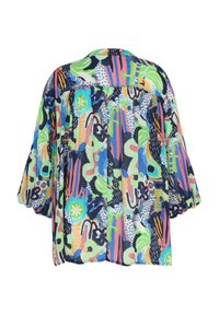 Chemise ample à manches longues avec un motif abstrait coloré comprenant des formes vertes, bleues, roses et noires sur fond blanc.