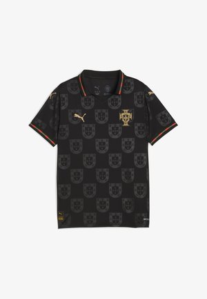 Camiseta tipo polo negra con un patrón repetido de escudos, logotipo dorado, detalles en rojo y verde en el cuello, y mangas cortas. Fabricada con material ligero.