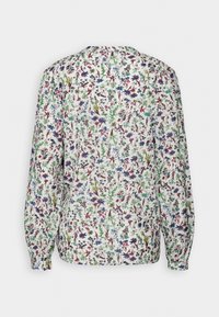 Blouse blanche à manches longues avec un petit imprimé floral coloré en rouge, bleu, vert et violet, vue de dos.