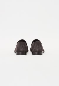 Fekete velúr slip-on cipők sima felülettel és lekerekített orrformával. Alul alacsony, elegáns gumitalpak láthatók.