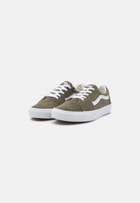 Olivengrøn ruskindsneakers med hvide snørebånd, en hvid sidestribe og et lavprofil design. Har farvekontrast syninger og en gummisål.