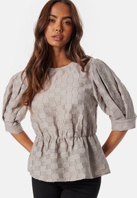 Blusa grigia chiara con maniche a palloncino, tessuto testurizzato con motivo a quadri, vita elastica e scollatura a girocollo.