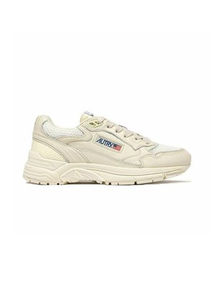 Sneaker sportiva color crema con tomaia in mesh e pelle, design con lacci, suola spessa e logo "Autry" con bandiera americana sul lato.