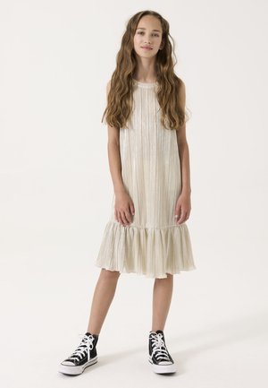 Robe plissée en crêpe métallisé avec une ourlet évasé, associée à des baskets hautes noires avec des accents et des lacets blancs.