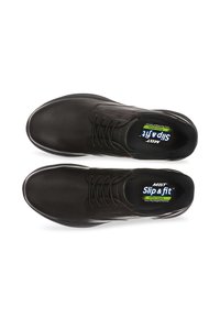 Chaussures noires en cuir avec un bout arrondi, design à lacets et semelle intérieure rembourrée étiquetée "MBT Slip & Fit". Texture lisse et silhouette épurée.