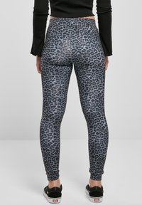 Høyt midje leggings i et grått og svart leopardmønster, laget av elastisk materiale, med slim fit og ankellengde.