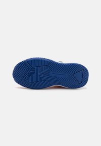 Semelle de chaussure en caoutchouc bleu avec des motifs de semelle en zigzag et en chevrons. Texture lisse avec une marque en relief et un accent triangulaire.