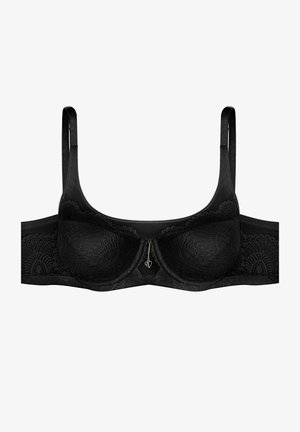 Black lace bra featuring underwire cups, adjustable straps, and a gold heart charm detail at the center. Smooth, textured fabric.