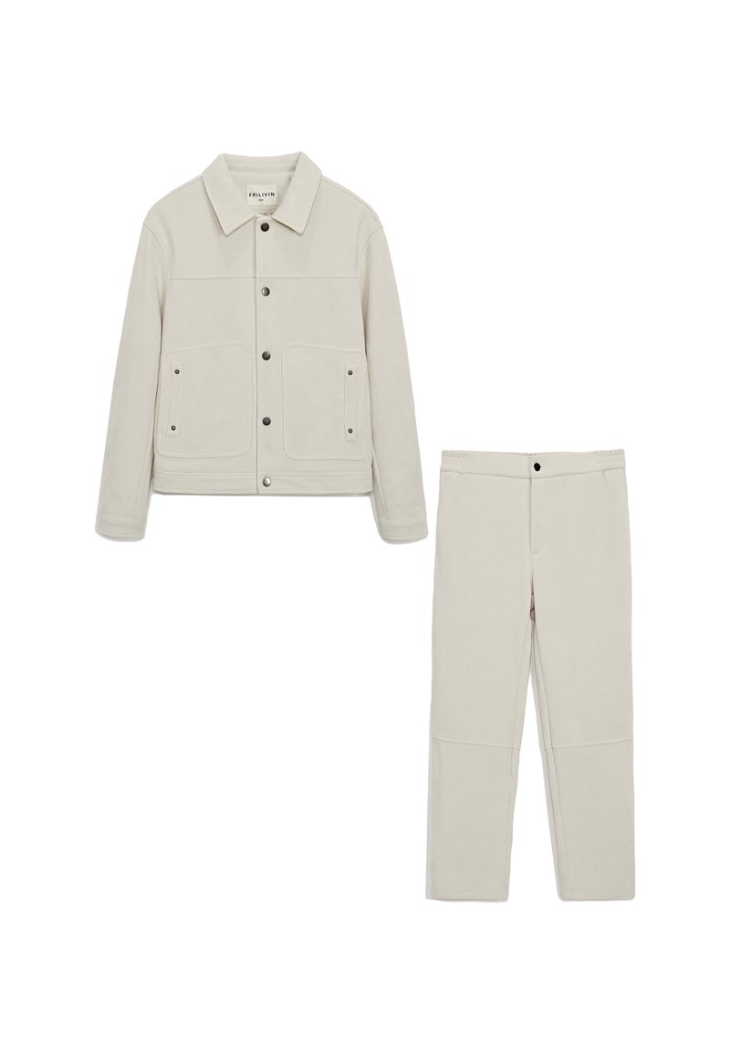 Veste en velours côtelé beige clair avec deux poches avant et des boutons-pression, assortie à un pantalon droit. Tissu lisse et texturé.