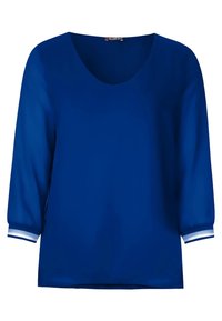 Blå topp med rundad hals och trekvartsärmar. Ärmarna har vita ränder vid muddarna. Tillverkad av ett slätt, ogenomskinligt tyg.