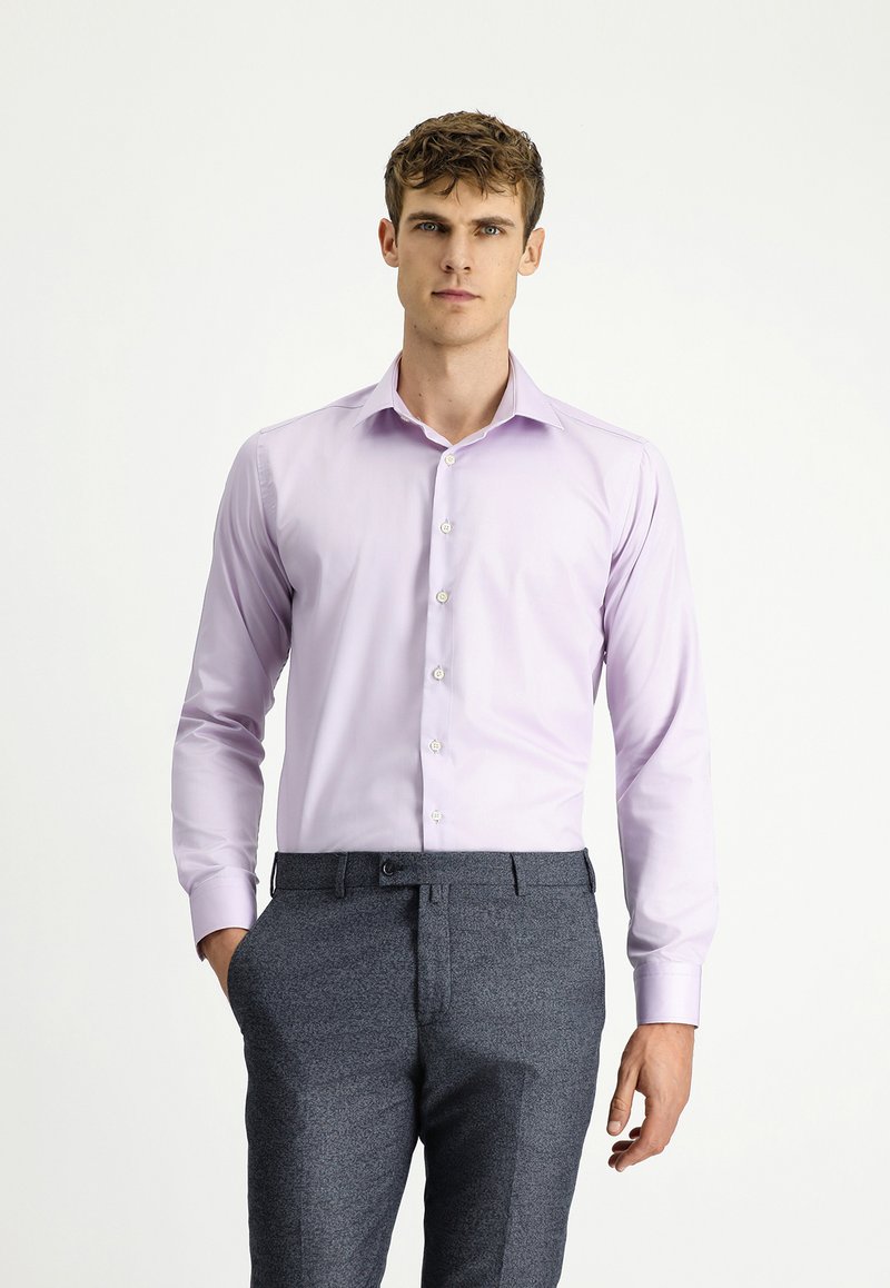 Camicia da uomo viola chiaro con maniche lunghe, chiusura a bottoni sul davanti e colletto classico, abbinata a pantaloni scuri con motivo.