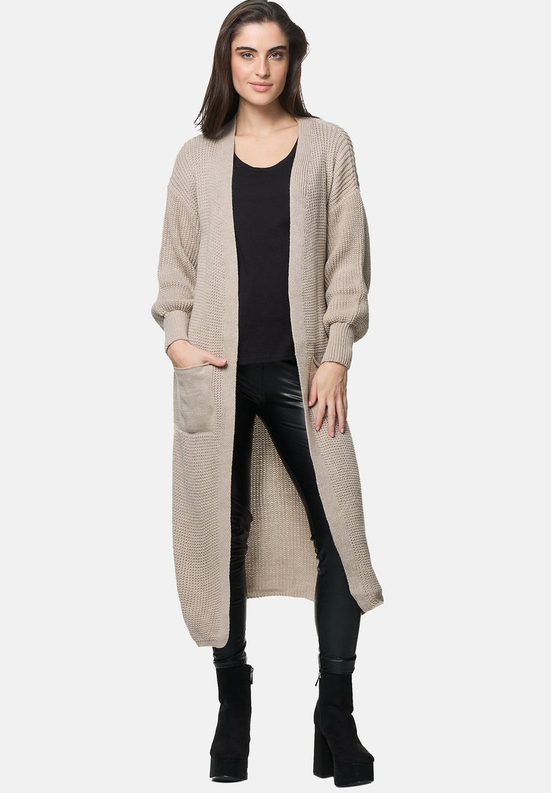 Beige lång cardigan tillverkad av strukturerad stickning, med sänkta axlar, en framficka och en öppen framsida.