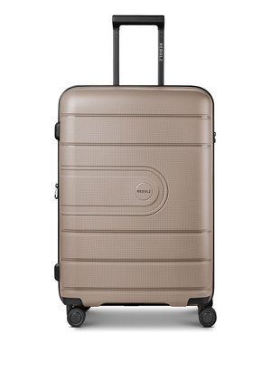 Maleta rígida beige de tamaño medio con cuatro ruedas y un asa negra extendida, nombre de la marca Redolz visible en el asa y en la parte delantera.