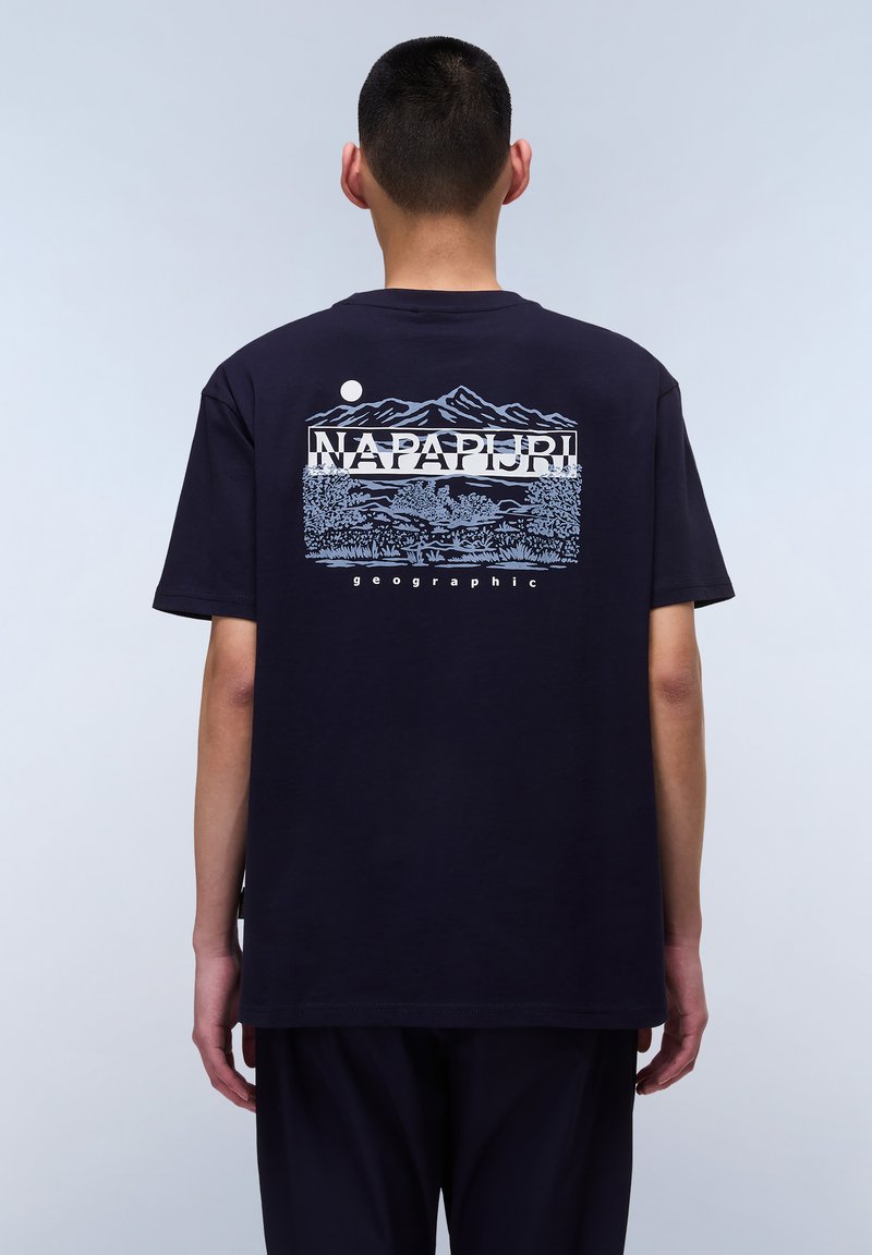 Marineblå bomulds-t-shirt med et bjergmotiv og "NAPAPIJRI" tekst i hvid og lys blå på ryggen. Rund halsudskæring og korte ærmer.