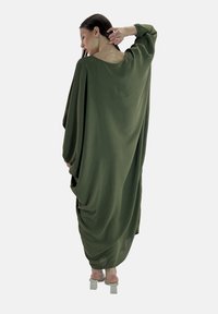Abito oversize verde oliva con tessuto drappeggiato, scollatura rotonda e maniche lunghe, caratterizzato da una silhouette fluida e una texture liscia.