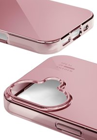 Pink acrylic phone case with a glossy finish, heart-shaped cutout, and logo embossed on the surface. Features cutouts for charging and speakers.