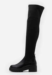 Botas negras hasta el muslo con punta de cuero liso y caña de tela texturizada. Presentan una suela gruesa y una lengüeta trasera para ponérselas fácilmente.