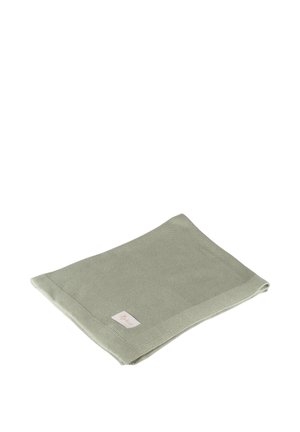 Light green knitted blanket folded with a small rectangular fabric label on one corner on a white background.