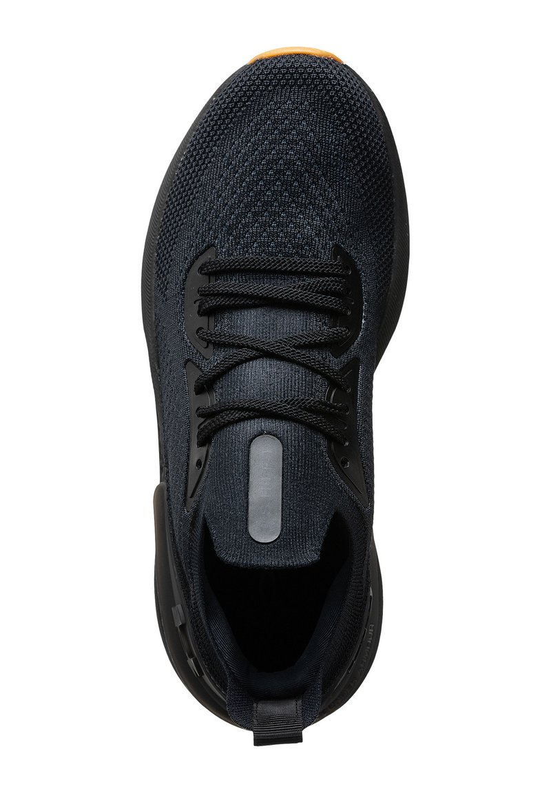 Scarpa da ginnastica nera e grigio scuro in maglia con lacci neri, striscia riflettente sulla linguetta e un piccolo accento arancione sulla punta.