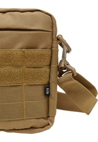 Brown fabric crossbody bag with a textured surface, featuring a strap, Velcro accents, and a durable zipper. Compact and rectangular design.