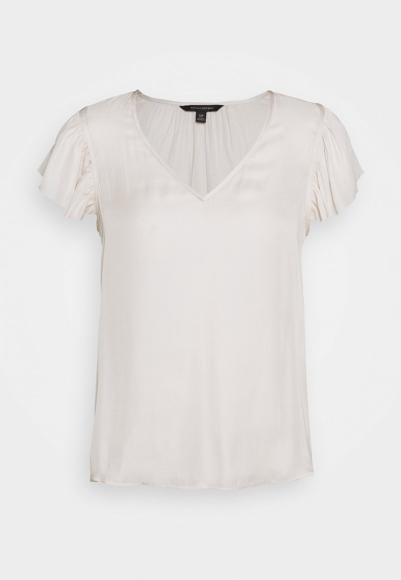 Ljusbeige blus med V-hals och korta volangärmar. Tillverkad av ett mjukt, lätt tyg med en avslappnad passform och rak nederkant.