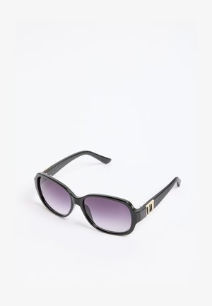 Crne pravokutne sunčane naočale s gradijent ljubičastim lećama i zlatnim detaljima na kracima, odložene na bijeloj površini.