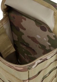 Taktikai táska cipzárral, khaki külső résszel és álcázott belsővel. Szövetpántokkal és texturált felületekkel a tartósság érdekében.