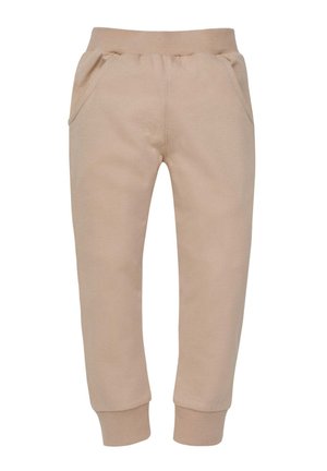 Beżowe dresy mają elastyczny pasek w talii, dwie boczne kieszenie i zwężane mankiety. Wykonane z miękkiej, gładkiej tkaniny dla komfortu.