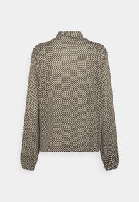 Braune Bluse mit Tupfenmuster, langen Ärmeln, weichem Stoff und Kragen. Verfügt über elastische Bündchen und eine lockere Passform.