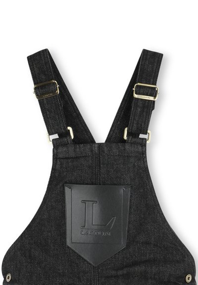 Zwarte denim tuinbroeken met verstelbare banden, goudkleurige hardware en een leren zakpatch met een gestileerde "L"-logo.