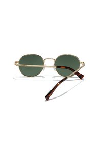 Ronde zonnebrillen met donkergroene lenzen, gouden metalen frame en schildpadbedrukte pootjes. Voorzien van neussteunen voor comfort en een lichtgewicht ontwerp.