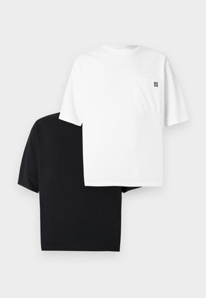 Due t-shirt, una bianca con una piccola tasca sul petto e logo, e una nera, entrambe in morbido cotone con maniche corte.