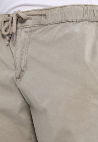 Beige bomullsshorts med resårmidja och dragsko. Har sidofickor och en mjuk, len textur.