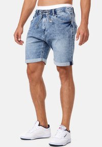 Lichtblauwe denimshorts met een elastische tailleband, aantrekkoord en opgerolde zoom. Bevat zijzakken en heeft een comfortabele pasvorm.