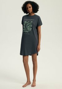 Wizytowa piżama w kolorze węglowym z krótkimi rękawami, z grafiką roślinną w odcieniach zieleni oraz napisem, o luźnym kroju i rozcięciami po bokach.