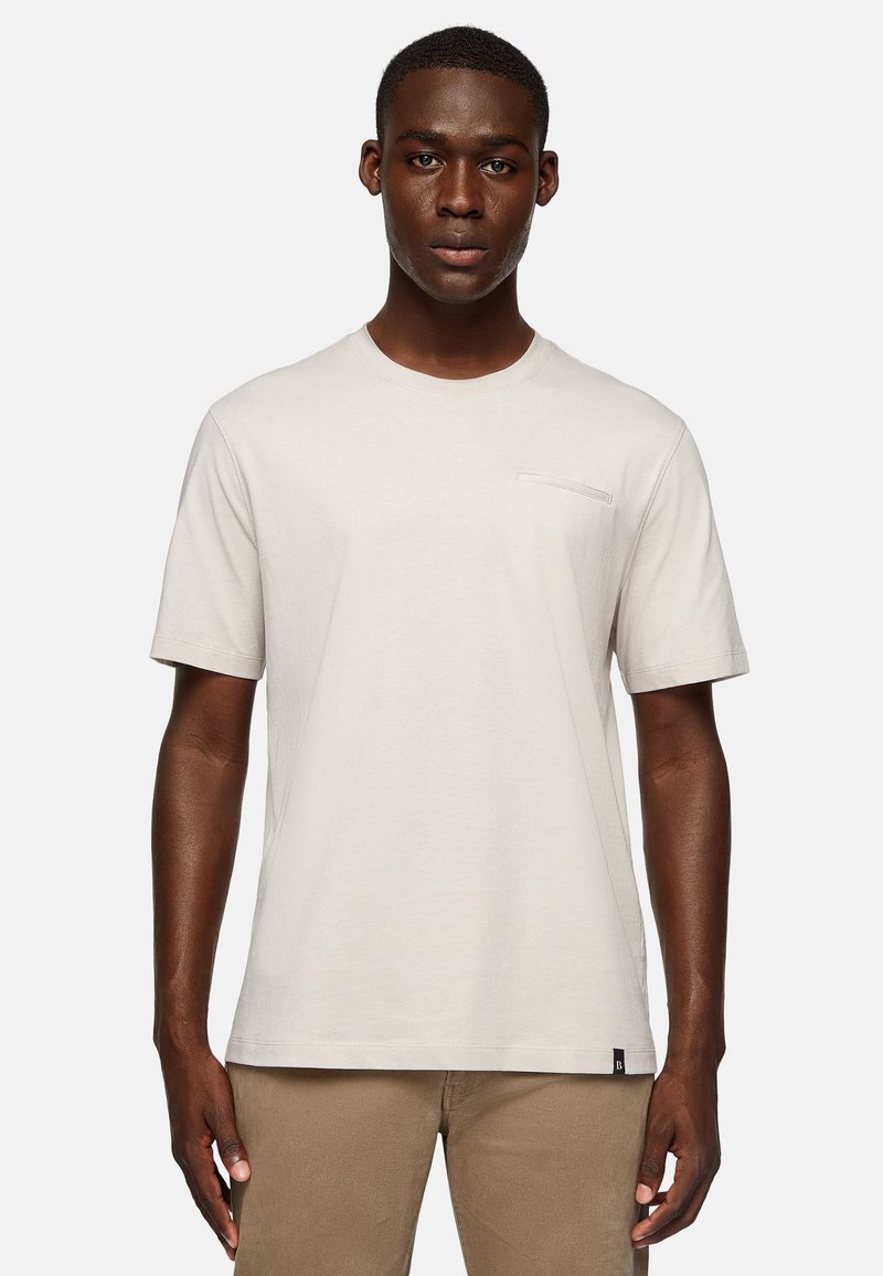 Light beige short-sleeve t-shirt with a crew neck and a small chest pocket detail. Soft fabric and relaxed fit.